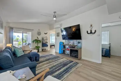 a living room with a blue couch and a tv at 1128 Tait Street, Unit D in Oceanside