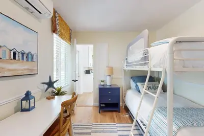 a bedroom with a bunk bed and a desk with a desk at Blue Oasis Cozy Home in San Diego
