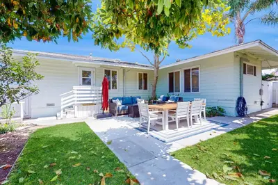 a white house with a table and chairs at Blue Oasis Cozy Home in San Diego