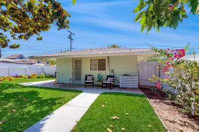 a small yellow house with two chairs in a yard at Blue Oasis Cozy Home in San Diego