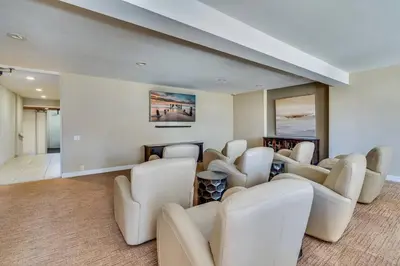 a waiting room with white chairs and a fireplace at Pacific Beach Resort Condo - Walk to the Beach in San Diego