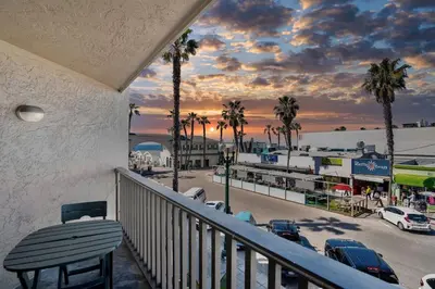 a balcony with a bench and a view of a parking lot at Beach Front Bliss - Entire Condo - Crystal Pier in San Diego