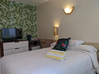 a bedroom with a white bed with a tv on it at El Rancho Motel in San Diego