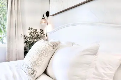 a white bed with white pillows on it at Beachside Bliss Spacious 3BR Retreat, Steps to Ocean in Oceanside