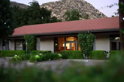 a house with a red roof and green bushes at Diamond Riviera Oaks Resort and Racquet Club 2BD in Ramona