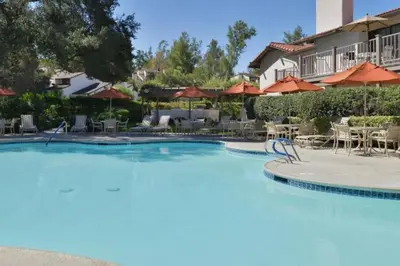 a large pool with chairs and umbrellas at a resort at Diamond Riviera Oaks Resort and Racquet Club 2BD in Ramona