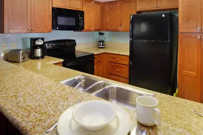 a kitchen with a sink and a black refrigerator at Diamond Riviera Oaks Resort and Racquet Club 2BD in Ramona