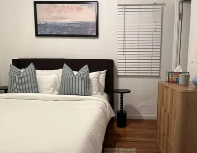 a bedroom with a white bed with pillows and a window at Modern Eclectic 1BR by Downtown, Airport & More in San Diego