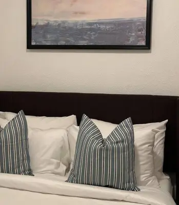 a bed with white pillows and a picture on the wall at Modern Eclectic 1BR by Downtown, Airport & More in San Diego
