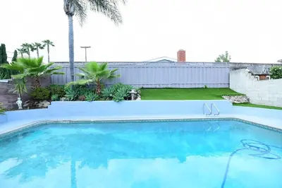 a swimming pool in a yard with a palm tree at Sunny San Diego, Entire home, Pool, Free Parking, BBQ, Pets allowed, family neighborhood! in San Diego