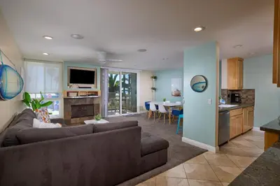 a living room with a couch and a kitchen at Oceanside Beach Condos in Oceanside