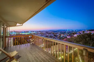 a balcony with a view of the city at night at Red Hawk Coastal Estate in San Diego