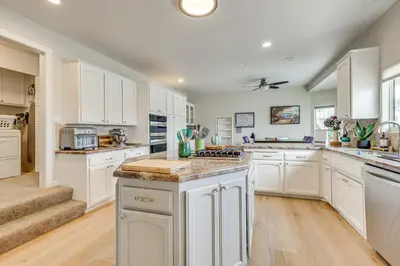 a kitchen with white cabinets and a counter top at San Marcos Getaway with Deck and Lake Views! in San Marcos