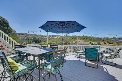 a deck with a table and chairs and an umbrella at San Marcos Getaway with Deck and Lake Views! in San Marcos