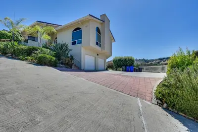 a house with a driveway in front of it at San Marcos Getaway with Deck and Lake Views! in San Marcos