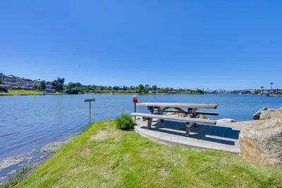 a picnic table on the shore of a lake at San Marcos Getaway with Deck and Lake Views! in San Marcos