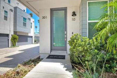 a house with a green door on a street at Blocks To Beach - Coastal Beach Decor - Garage Parking - Gated Community - 30 Day Fully Furnished in Oceanside