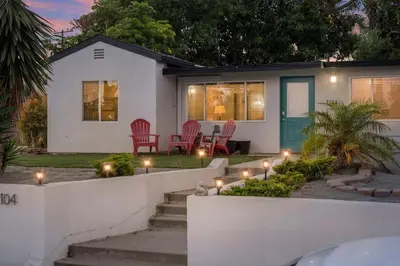a white house with chairs and lights in the yard at Sunlit Shores beachside Bliss in San Diego