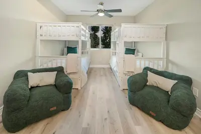a living room with two chairs and two bunk beds at Sunlit Shores beachside Bliss in San Diego