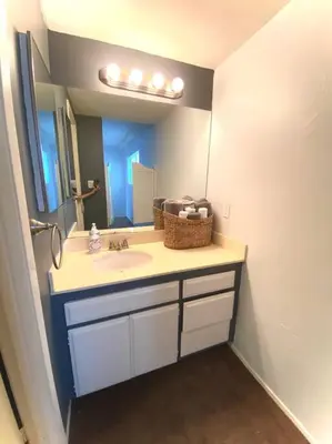 a bathroom with a sink and a large mirror at The Downtown Blue Bungalow Escape in San Diego