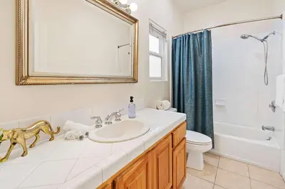a bathroom with a sink and a toilet and a mirror at Catch n' Relax on Nimitz- Minutes from the Harbor in San Diego