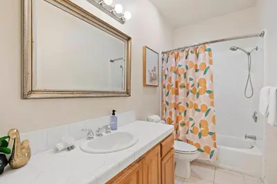 a bathroom with a sink and a toilet and a mirror at Catch n' Relax on Nimitz- Minutes from the Harbor in San Diego