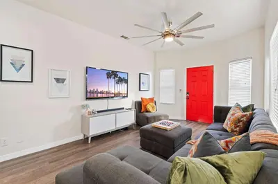 a living room with a couch and a red door at Catch n' Relax on Nimitz- Minutes from the Harbor in San Diego
