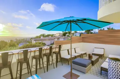 a patio with a table and chairs and an umbrella at Ultimate Getaway: Spa Game Rooms Firepit Views in San Diego