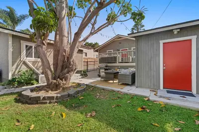 a house with a red door and a tree at Endless Summer Beach Studio - Beach - AC - Shops in San Diego