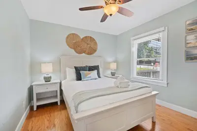 a bedroom with a white bed with a ceiling fan at Endless Summer Cottage - Patio - AC - Beach in San Diego