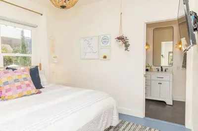 a white bedroom with a bed and a bathroom at Little Italy 3BD Home with Huge Patio & Backyard in San Diego