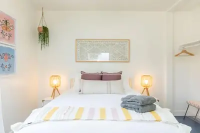 a bedroom with a large white bed with two lamps at Little Italy 3BD Home with Huge Patio & Backyard in San Diego
