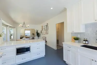 a kitchen with white cabinets and a blue floor at Little Italy 3BD Home with Huge Patio & Backyard in San Diego