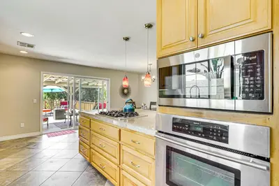 a kitchen with wooden cabinets and stainless steel appliances at Poway Retreat with Stunning Sunset and Mountain Views! in Poway
