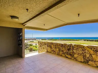 a patio with a stone wall and a view of the ocean at Ocean Breeze 2 bedroom in San Diego