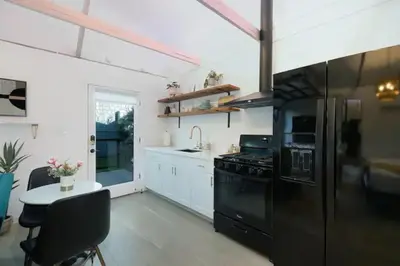 a kitchen with a black refrigerator and a table at Quaint Studio for 2 in the Heart of Little Italy in San Diego