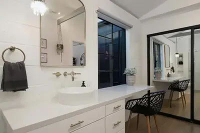 a white bathroom with a sink and a mirror at Quaint Studio for 2 in the Heart of Little Italy in San Diego