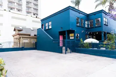 a blue house with a large driveway at Bright, Spacious 4 BD in the Heart of Little Italy in San Diego