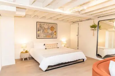 a bedroom with a large white bed and a couch at Lovely Studio in the Heart of Little Italy in San Diego