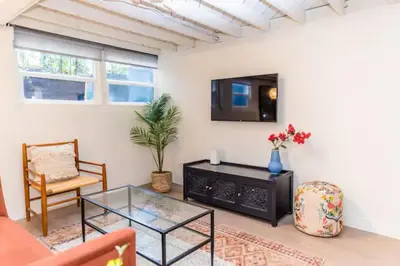 a living room with a tv and a glass table at Lovely Studio in the Heart of Little Italy in San Diego