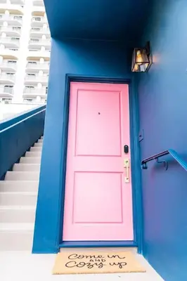 a pink door in a blue wall with stairs at Lovely Studio in the Heart of Little Italy in San Diego