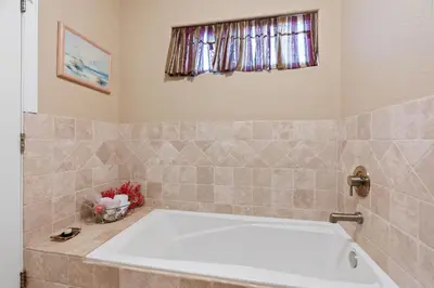 a bath tub in a bathroom with a window at Sunsets at the Beach House in Oceanside