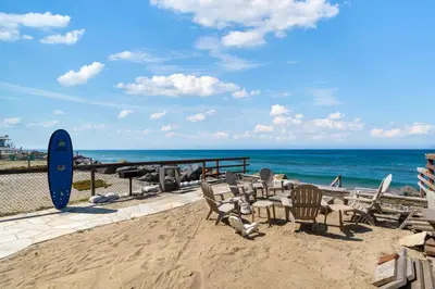 a group of chairs and a table on the beach at Sunsets at the Beach House in Oceanside