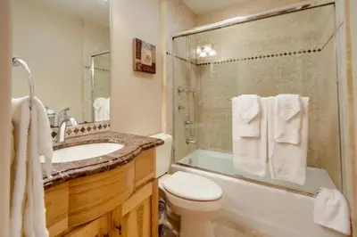 a bathroom with a sink and a toilet and a shower at Steps to the boardwalk & beach with AC, WiFi, spacious deck, prime location in San Diego