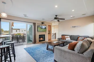 a living room with a couch and a fireplace at Steps to the boardwalk & beach with AC, WiFi, spacious deck, prime location in San Diego