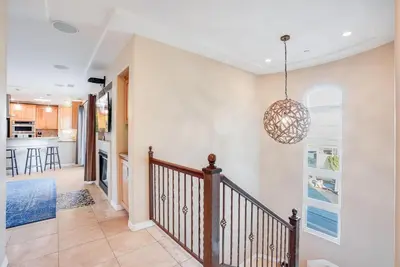 a staircase in a home with a chandelier at Steps to the boardwalk & beach with AC, WiFi, spacious deck, prime location in San Diego