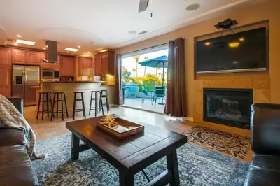 a living room with a table and a fireplace at Steps to the boardwalk & beach with AC, WiFi, spacious deck, prime location in San Diego