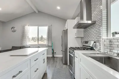 a kitchen with white cabinets and a stove top oven at 2 Mi to Downtown Escondido Apt with Balconies in Escondido