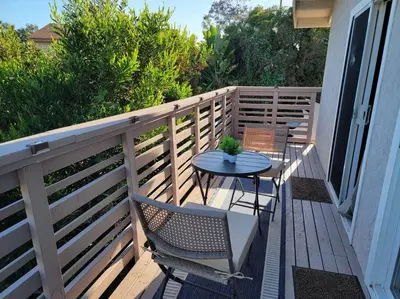 a patio with two chairs and a table on a balcony at San Diego Oasis with Hot Tub, Gym, Outdoor Theater, Huge Yard in San Diego