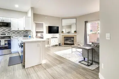 an open kitchen and living room with a fireplace at Sunny San Diego Condo with Pool Access Near Wineries in San Diego